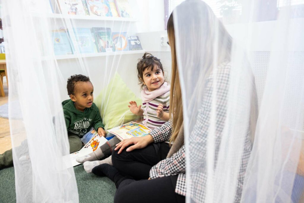 Pedagog sitter med barn i en lugn vrå